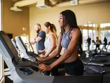 Woman training on a row of treadmills